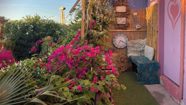 A room with a bed, a clock, and a wall decorated with patterned textiles. - Magic ArtHouse at the heart of Las Vegas 
Near everything (North Las Vegas)