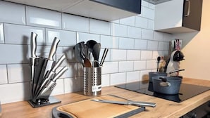 Uma cozinha com bancada de madeira, tábua de corte e diversos utensílios.