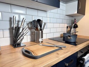 A kitchen with a wooden countertop, a cutting board, and various utensils. - Prime TS1 Location Walk to Shop, Uni and Transport (Middlesbrough)