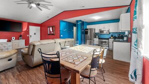 A compact living space with a dining area, kitchen, and a ceiling fan. - Pool/Hot Tub/Golf Cart + 3 Min Stroll to Beach (Panama City)
