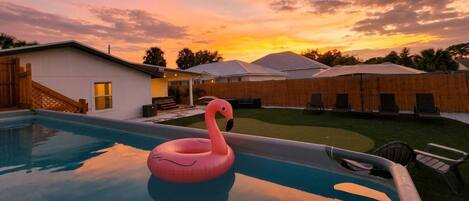 Private sunset pool oasis with lounge chairs and a fun flamingo float