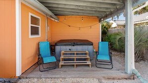 A covered patio with a hot tub, two blue chairs, and a wooden bench. - Pool/Hot Tub/Golf Cart + 3 Min Stroll to Beach (Panama City)