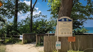 A beach entrance sign with guidelines and a no dogs allowed sign.