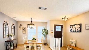 A spacious dining area with a wooden table and chairs, a bench, and a white railing. - Family Retreat Near Randolph AFB, Patio & Comfort (Converse)