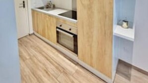 Una cocina moderna con armarios de madera, horno empotrado y encimera.