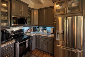 A kitchen with stainless steel appliances, granite countertops, and dark cabinetry. - Breathtaking Grandfather View has a truly Breathtaking view of Grandfather Mount (Boone)