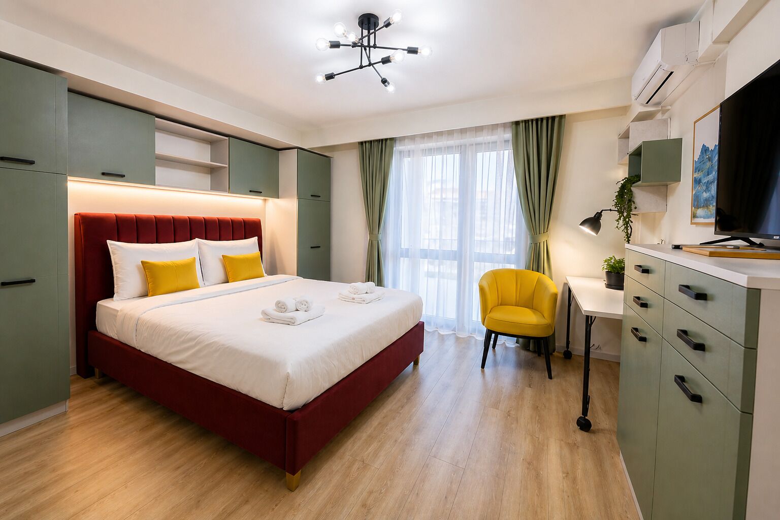 Una habitación de hotel con cama, escritorio, silla y televisión.