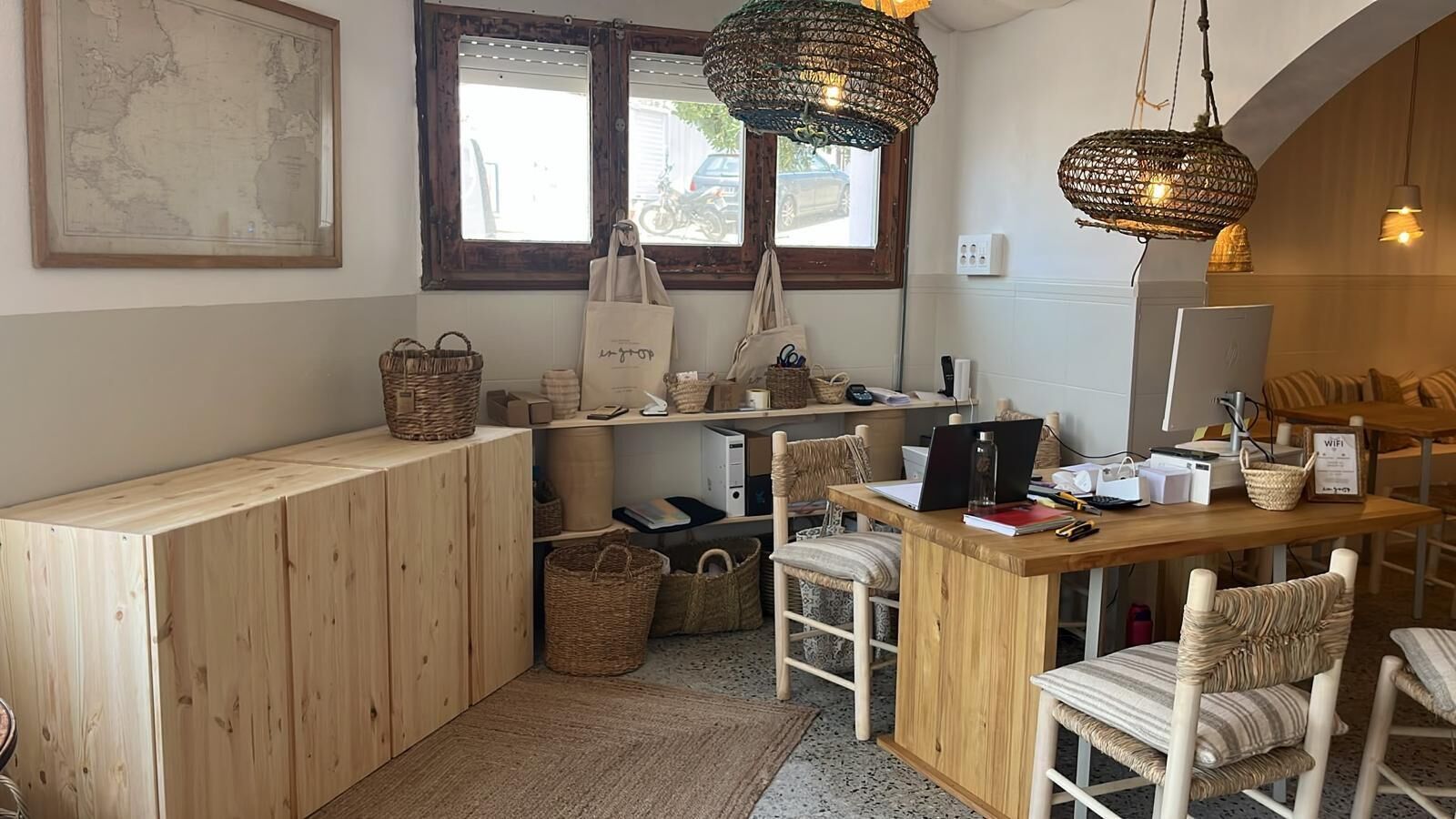 A cozy, well-organized workspace with a wooden desk, wicker baskets, and a laptop.