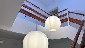 A staircase with wooden railings and two spherical pendant lights.