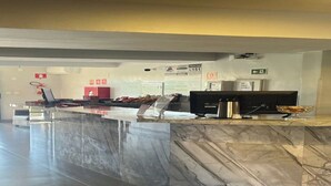 A reception area with a marble counter, a computer, a coffee machine, and a fire extinguisher. - CARDOSO PALACE HOTEL RIO VERDE (Rio Verde)