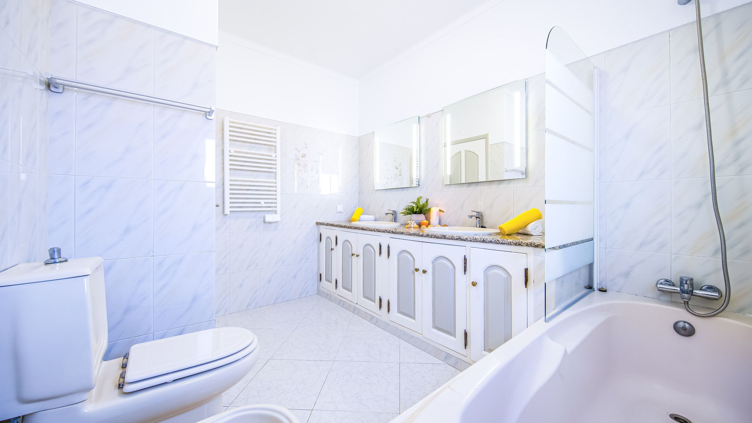 Ein modernes Badezimmer mit Toilette, Waschbecken und Badewanne.