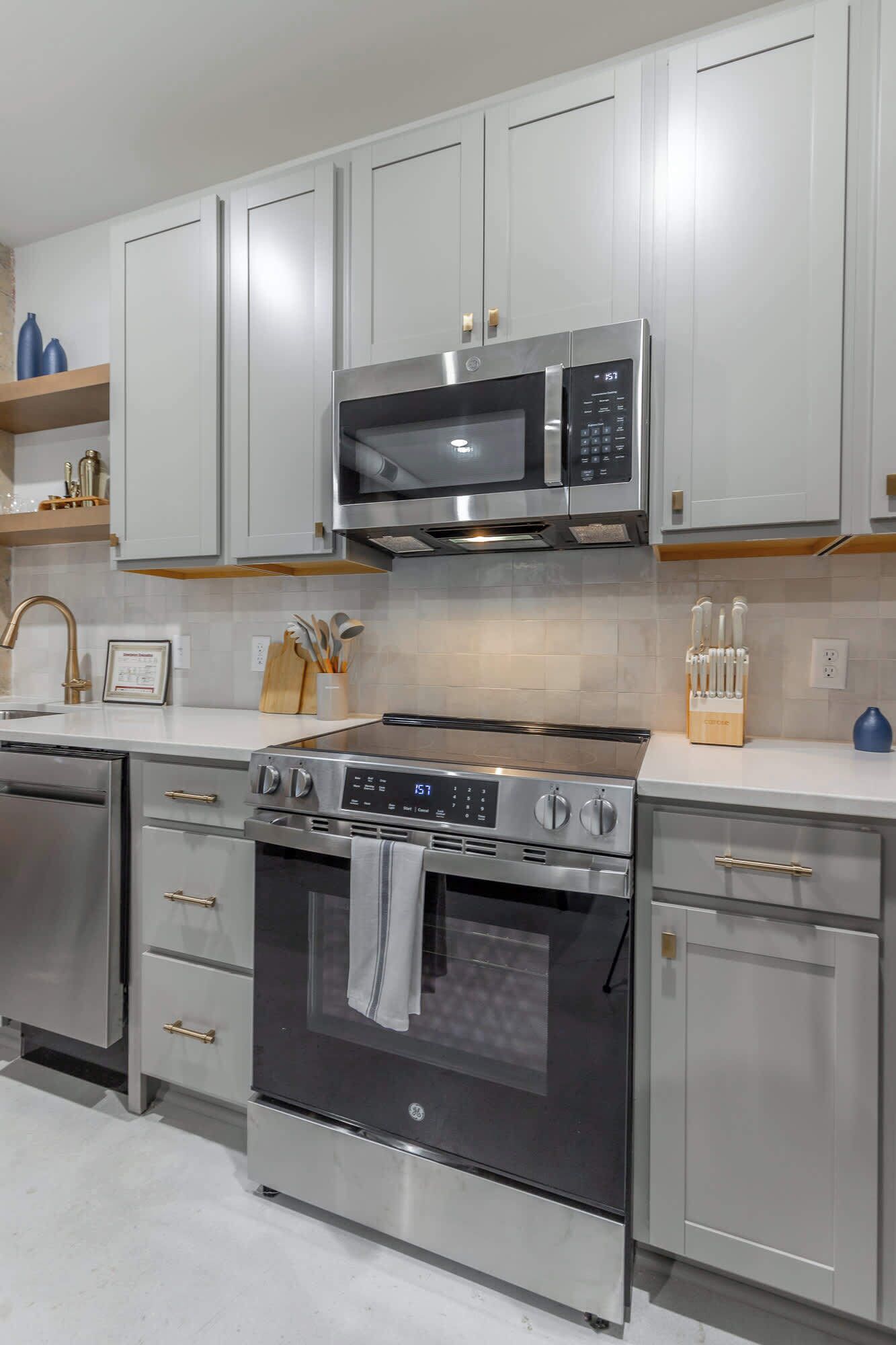 A modern kitchen with stainless steel appliances, including a microwave, oven, and dishwasher.