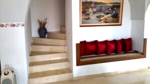 A staircase leading to a landing with a bench and a painting above it. - Stylish villa in yasmine hamamet tourist zone, 5 min from carthage lind park. (Yasmine Hammamet)
