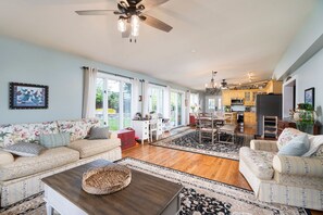 A spacious living room with a sofa, coffee table, and a dining area with chairs and a table. - Shalom at Shenandoah | Pool, Sauna & Views (Swoope)