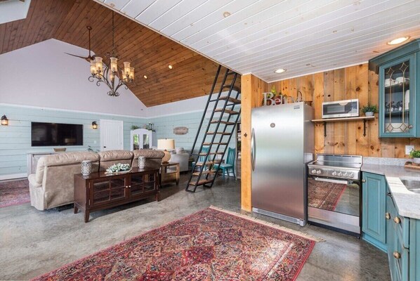 A kitchen with a refrigerator, stove, and wooden cabinets. - Shalom at Shenandoah | Pool, Sauna & Views (Swoope)