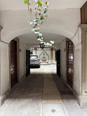 A corridor with a car parked at the end, a gate, and a fountain. - Cozy near Reforma and Juarez (Ciudad de México)