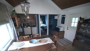 Una cocina compacta con microondas, una mesa de comedor con sillas y un refrigerador pequeño.