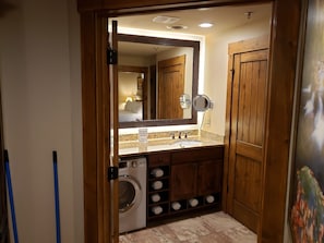 A bathroom with a built-in washing machine, a sink, and a large mirror. - 1-BR Mountain Cabin Westgate Smoky Mtn Resort & Waterpark incl waterpark passes. (Gatlinburg)