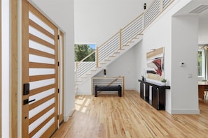 Ein modernes Interieur mit einer Holztreppe, einer Bank und einem Konsolentisch.