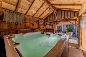 A wooden spa area with a hot tub, wooden beams, and wicker furniture. - Holiday Home “Enjoy the Spa All Year Round” with Private Terrace, Garden & Wi-Fi (La Teste-de-Buch)
