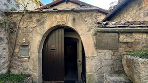 Un edificio de piedra con puerta de madera, un cartel que dice 'Gîte La Cardabelle' y una pequeña ventana con el número '64'.