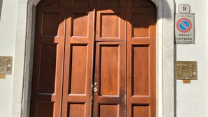 Una puerta doble de madera grande con un letrero que indica que es zona de prohibido estacionar.