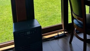 Una stanza con un'ampia finestra che si affaccia su un prato verde e una montagna.