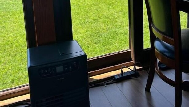 Una habitación con un ventanal que ofrece vistas a un campo verde y una montaña.