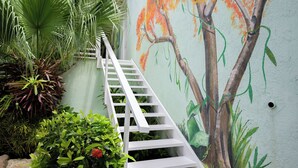 A white staircase leading up to a room with a mural of a tree. - Happy Hideaway - Private Resort Week, Sleeps 6 (Jan Thiel)