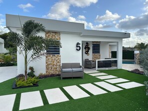 A modern house with a stone facade, a number '5' sign, outdoor seating, and a pool. - Villa Esmeralda-Peaceful 2-bedroom house with AC in charming Willemstad (Willemstad)