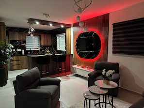 A modern living room with a sofa, a coffee table, and a TV. - Villa Esmeralda-Peaceful 2-bedroom house with AC in charming Willemstad (Willemstad)