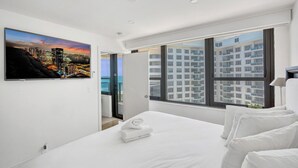 Ein modernes Hotelzimmer mit einem großen Bett, Stadtblick und einem Balkon.