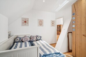 Ein Schlafzimmer mit einem Bett, einem Holzschrank und einer Treppe.
