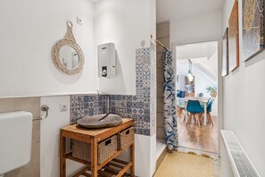 Ein Badezimmer mit Waschbecken, Spiegel und gemusterten Fliesen.