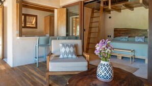 A modern interior with a sofa, a chair, a wooden table, and a vase with flowers. - Mangle Rojo Palafitos (Boca de Iguanas)