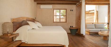 Une chambre à coucher avec un lit en bois, une table de chevet, une fenêtre et une vue sur un espace extérieur.