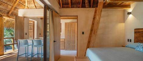 A modern bedroom with a large bed, a glass door leading to a balcony, and a wooden ceiling.