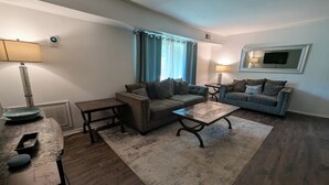 A living room with two sofas, a coffee table, a side table, and a lamp. - Eclips 2-bedroom condo in Central Raleigh (Raleigh)