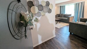 A living room with a modern sofa, a coffee table, and a decorative wall with circular patterns. - Eclips 2-bedroom condo in Central Raleigh (Raleigh)