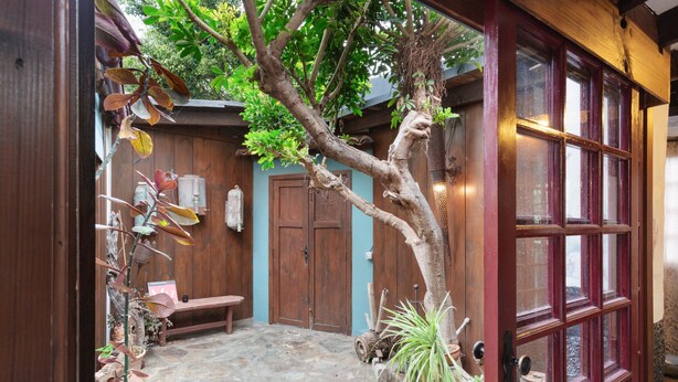 A courtyard with a wooden door, a bench, and potted plants. - Vacation Home 'Casa Afrikika' with Sea View, Private Terrace and Wi-Fi (Las Cruces)