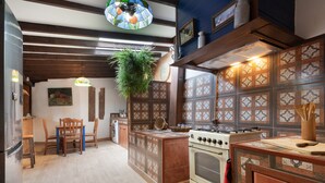 A kitchen with a stove, oven, and wooden cabinets. - Vacation Home 'Casa Afrikika' with Sea View, Private Terrace and Wi-Fi (Las Cruces)