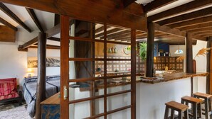 A rustic interior with exposed wooden beams, a stone floor, a bar area with stools, and a traditional Japanese sliding door. - Vacation Home 'Casa Afrikika' with Sea View, Private Terrace and Wi-Fi (Las Cruces)