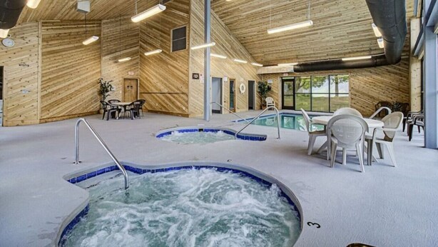 Un área de spa con un jacuzzi, una piscina y zonas de descanso.
