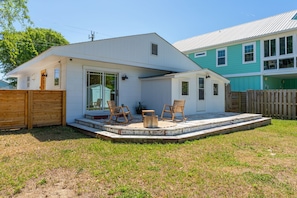 A single-story house with a covered patio, a fenced yard, and a neighboring house. - "A Weekend at Gary's" (Carolina Beach)