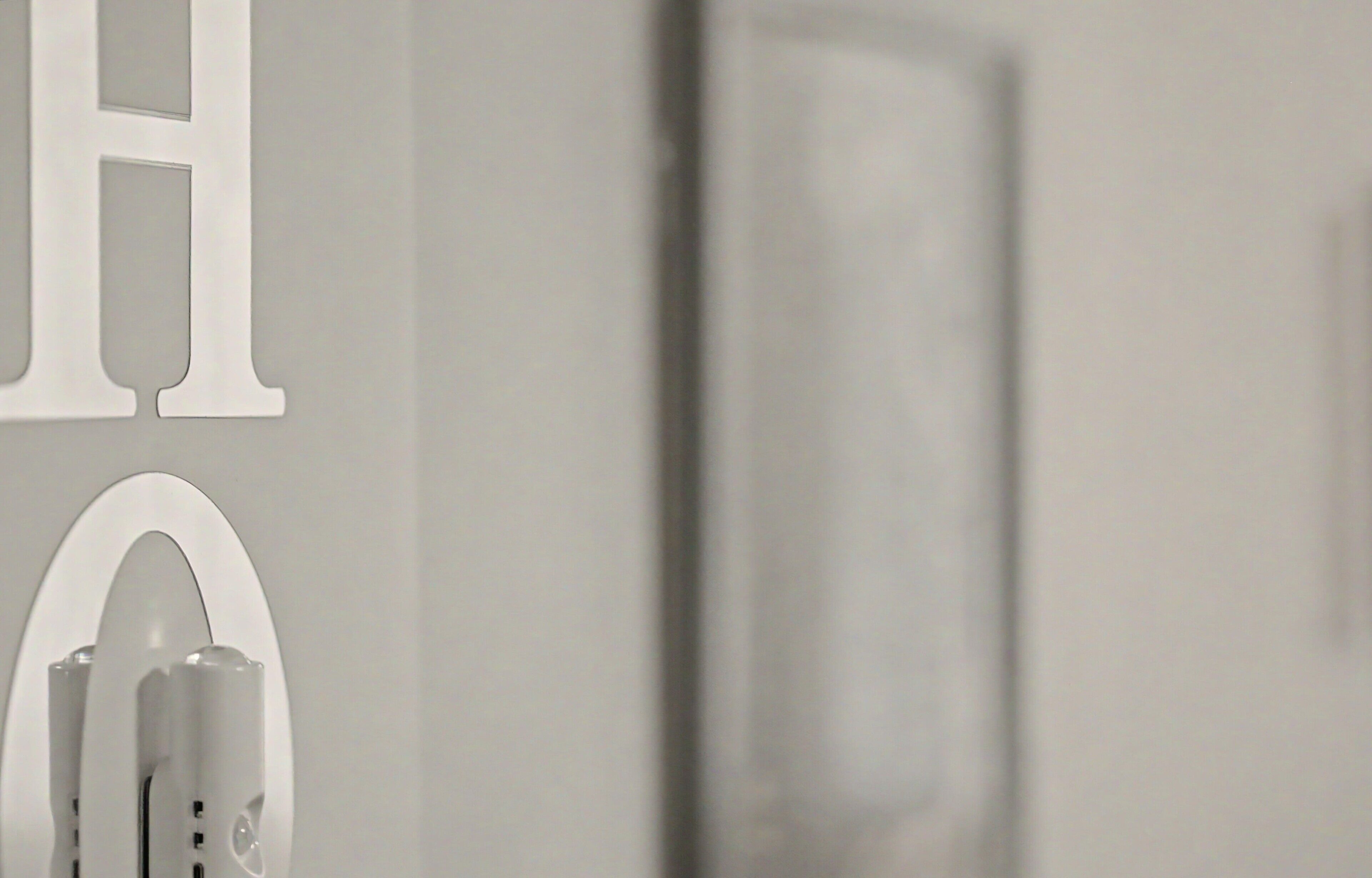A bathroom with a mirror, a towel rack, and a wall-mounted light fixture.