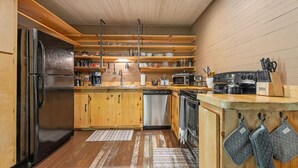 A kitchen with wooden cabinets, a refrigerator, a dishwasher, a stove, and a microwave. - Dreamy Mountaintop Escape for Two | Sauna & Views (Blue Ridge)