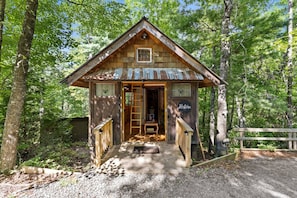 Eine rustikale Holzhütte mit Veranda und einem Schild mit der Aufschrift 'Restore'.