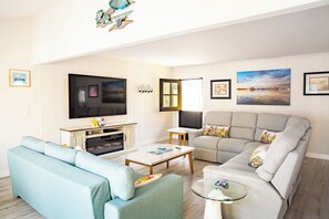 Ein Wohnzimmer mit einer Couch, einem Couchtisch, einem Fernseher und einem Kamin.