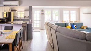 Een moderne keuken met een ingebouwde oven, een waterdispenser en een eethoek met een tafel en stoelen.