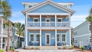 Une maison à deux étages dotée d’un balcon, d’un porche et d’une pancarte indiquant le prix de la location.